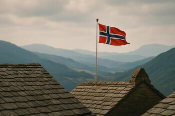 Small flag above slate roofs with distant ridges